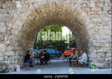 (240719) -- ISTANBUL, 19 luglio 2024 (Xinhua) -- le persone riposano sotto un arco dell'Acquedotto di Valente a Istanbul, T¨¹rkiye, 18 luglio 2024. L'acquedotto di Valente è un importante acquedotto romano di Istanbul. Come parte di un più ampio sistema di approvvigionamento idrico, fu completato alla fine del IV secolo d.C. durante il regno dell'imperatore romano Valente, da cui prende il nome. La struttura è notevole per il suo impressionante design ingegneristico e architettonico. L'acquedotto è stato costruito utilizzando una combinazione di pietra e mattoni, e presenta una serie di archi che sostengono il canale d'acqua sopra. Oggi, t Foto Stock