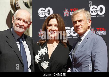 Christoph Waltz sostiene i produttori Michael G. Wilson e Barbara Broccoli alla cerimonia delle impronte delle mani al TCL Chinese Theatre di Hollywood, USA Foto Stock