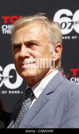 Christoph Waltz sostiene i produttori Michael G. Wilson e Barbara Broccoli alla cerimonia delle impronte delle mani al TCL Chinese Theatre di Hollywood, USA Foto Stock