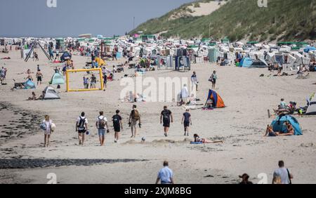 Baltrum, Germania. 19 luglio 2024. I turisti camminano e si siedono sulla spiaggia dell'isola di Baltrum. Con il miglior tempo estivo, sono attesi numerosi turisti sulla più piccola isola della Frisone orientale. Crediti: Focke Strangmann/dpa/Alamy Live News Foto Stock