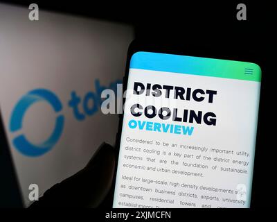 Stoccarda, Germania, 05-21-2022: Persona che possiede uno smartphone con pagina Web della National Central Cooling Company PJSC (Tabreed) sullo schermo con logo. Concentrati Foto Stock