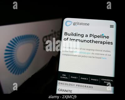 Stoccarda, Germania, 05-21-2022: Persona che detiene il cellulare con pagina web della società statunitense di biotecnologie Gritstone bio Inc sullo schermo davanti al logo. Concentrati Foto Stock
