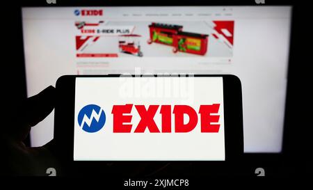 Stoccarda, Germania, 05-22-2022: Persona che detiene un telefono cellulare con il logo della società indiana di batterie Exide Industries Ltd. Sullo schermo davanti alla pagina Web. Foto Stock