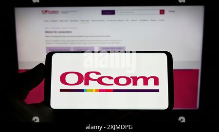 Stoccarda, Germania, 06-04-2022: Persona che detiene un cellulare con il logo dell'Ufficio delle comunicazioni (Ofcom) dell'autorità britannica sullo schermo di fronte Foto Stock