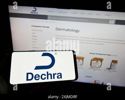 Stoccarda, Germania, 06-04-2022: Persona che detiene uno smartphone con il logo della società britannica Dechra Pharmaceuticals plc sullo schermo davanti al sito web. Foto Stock