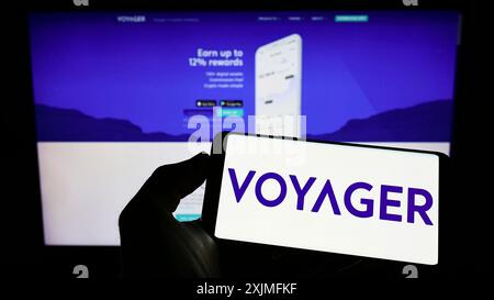 Stoccarda, Germania, 06-25-2022: Persona che detiene un cellulare con il logo della società americana di criptovalute Voyager Digital LLC sullo schermo di fronte a Foto Stock