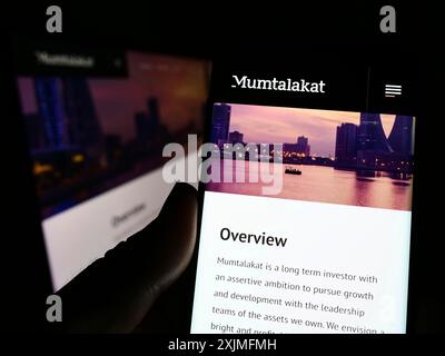 Stoccarda, Germania, 06-25-2022: Persona che possiede uno smartphone con il sito web della Bahrain Mumtalakat Holding Company sullo schermo davanti al logo. Concentrati su Foto Stock