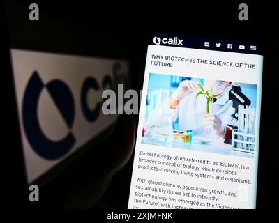 Stoccarda, Germania, 06-19-2022: Persona che detiene un cellulare con sito web della società tecnologica australiana Calix Limited sullo schermo davanti al logo. Foto Stock