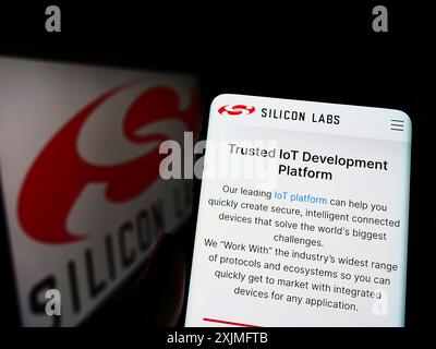 Stoccarda, Germania, 06-19-2022: Persona che detiene uno smartphone con pagina web della società di semiconduttori Silicon Laboratories Inc. Su schermo con logo. Concentrati Foto Stock