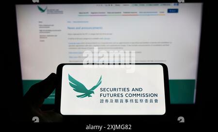 Stoccarda, Germania, 07-10-2022: Persona con smartphone con logo della Hong Kong Securities and Futures Commission (SFC) sullo schermo di fronte Foto Stock