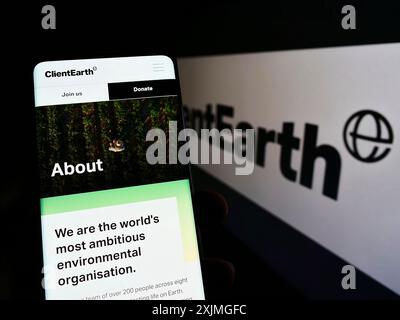 Stoccarda, Germania, 07-10-2022: Persona che tiene un cellulare con pagina web dell'ente benefico di diritto ambientale ClientEarth sullo schermo davanti al logo. Concentrati su Foto Stock