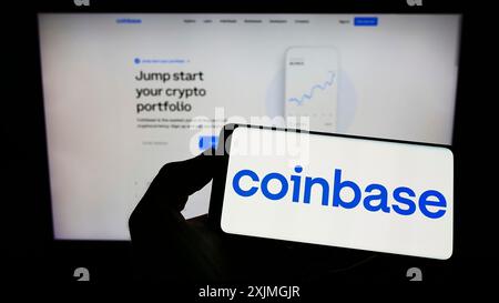 Stoccarda, Germania, 07-15-2022: Persona che detiene un cellulare con il logo della società americana di scambio cripto Coinbase Global Inc. Sullo schermo di fronte Foto Stock