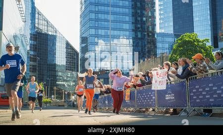 Ritratto di una Runner femminile sorridente Plus size che celebra e dimostra la sua forza di volontà. Simpatici partecipanti alla maratona cittadina che salutano il pubblico Foto Stock