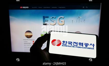 Stoccarda, Germania, 07-24-2022: Persona che tiene un cellulare con il logo della Korea Electric Power Corporation (KEPCO) sullo schermo davanti all'azienda Foto Stock