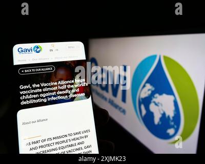 Stoccarda, Germania, 07-31-2022: Persona che tiene il cellulare con sito web di partnership sanitaria Gavi, l'alleanza vaccino sullo schermo con logo. Concentrati su Foto Stock