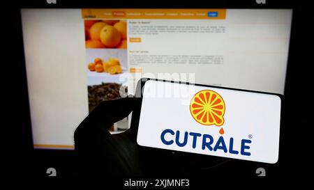 Stoccarda, Germania, 09-14-2022: Persona che detiene lo smartphone con il logo della società brasiliana Sucocitrico Cutrale Ltda. sullo schermo davanti al sito web. Foto Stock
