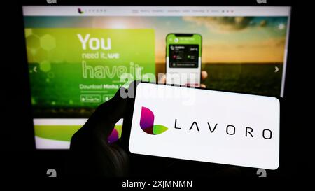 Stoccarda, Germania, 09-19-2022: Persona con smartphone con logo dell'azienda agricola brasiliana lavoro Agro sullo schermo davanti al sito web. Concentrati Foto Stock