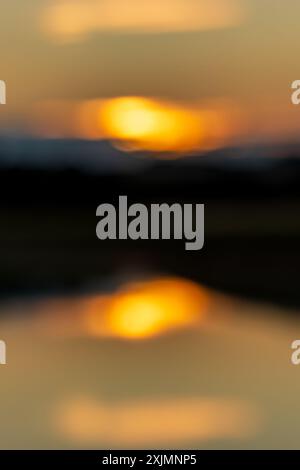 Una suggestiva fotografia sfocata di un cielo al tramonto che si riflette nel fiume Ouse nel Sussex Foto Stock