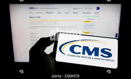 Stoccarda, Germania, 09-22-2022: Persona che tiene il cellulare con il logo dei centri per Medicare e servizi Medicaid (CMS) sullo schermo davanti alla pagina web. Foto Stock