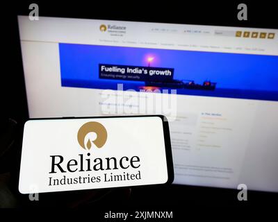 Stoccarda, Germania, 09-22-2022: Persona con smartphone con logo della società indiana Reliance Industries Limited sullo schermo davanti al sito web. Foto Stock