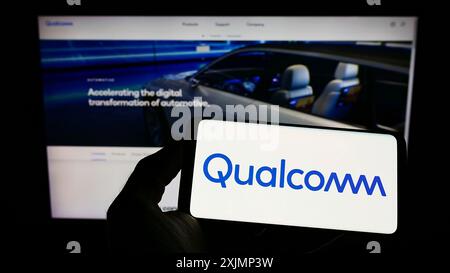 Stoccarda, Germania, 09-26-2022: Persona che detiene il cellulare con il logo della società americana di semiconduttori Qualcomm incorporato sullo schermo di fronte Foto Stock