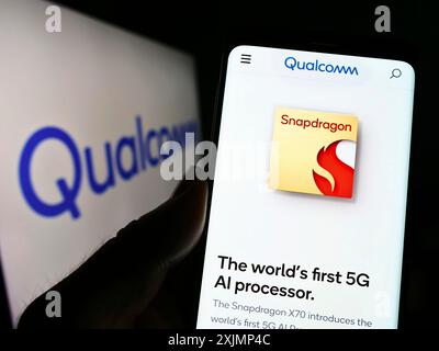 Stoccarda, Germania, 09-26-2022: Persona che detiene il cellulare con pagina web della società americana di semiconduttori Qualcomm incorporata sullo schermo con logo. Concentrati su Foto Stock