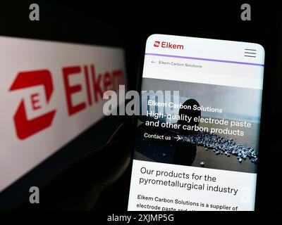 Stoccarda, Germania, 09-25-2022: Persona che detiene il cellulare con pagina web della società norvegese di siliconi Elkem ASA sullo schermo davanti al logo. Concentrati su Foto Stock