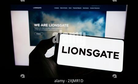 Stoccarda, Germania, 10-01-2022: Persona con smartphone e logo della Lions Gate Entertainment Corporation (Lionsgate) sullo schermo di fronte Foto Stock