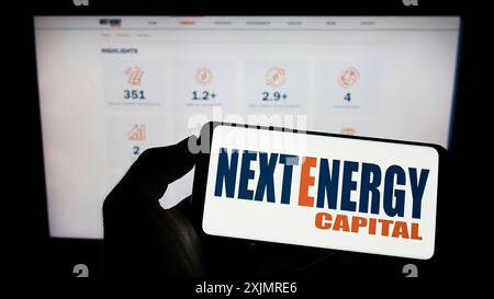 Stoccarda, Germania, 10-03-2022: Persona che detiene il cellulare con il logo della società britannica NextEnergy Capital Limited sullo schermo davanti all’azienda Foto Stock