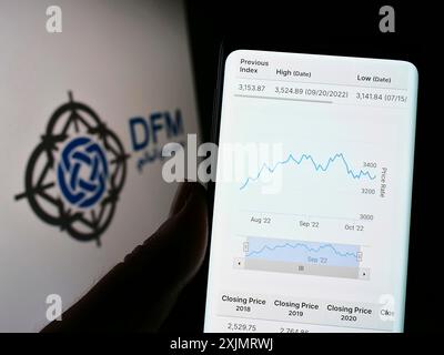 Stoccarda, Germania, 10-13-2022: Persona che detiene il cellulare con pagina web della borsa valori Dubai Financial Market (DFM) sullo schermo davanti al logo. Foto Stock