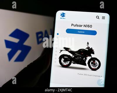 Stoccarda, Germania, 10-15-2022: Persona che detiene il cellulare con pagina web dell'azienda automobilistica indiana Bajaj Auto Limited sullo schermo con logo. Concentrati su Foto Stock