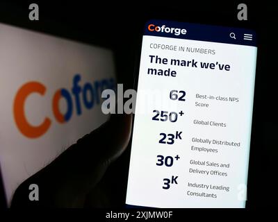 Stoccarda, Germania, 23-10-2022: Persona con smartphone e sito web dell'azienda indiana di tecnologia dell'informazione Coforge Ltd. Su schermo con logo. Foto Stock