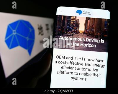 Stoccarda, Germania, 10-16-2022: Persona che tiene il cellulare con pagina web dell'azienda automobilistica cinese Horizon Robotics Inc. Sullo schermo con logo. Concentrati Foto Stock