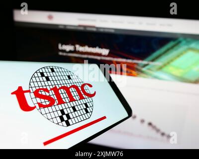 Stoccarda, Germania, 11-30-2022: Telefono cellulare con logo della società Taiwan Semiconductor Manufacturing Company (TSMC) su schermo con sito web. Concentrati su Foto Stock