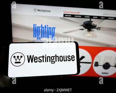 Stoccarda, Germania, 12-01-2022: Persona che detiene il cellulare con il logo della società americana Westinghouse Electric Corporation sullo schermo di fronte Foto Stock