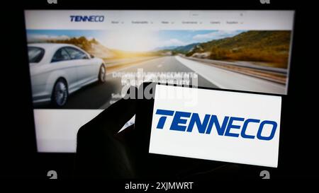 Stoccarda, Germania, 12-03-2022: Persona che detiene il cellulare con il logo della società automobilistica statunitense Tenneco Inc. Sullo schermo di fronte alla pagina web aziendale. Foto Stock