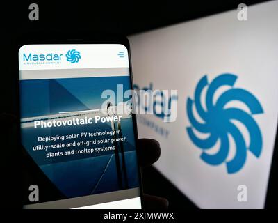 Stoccarda, Germania, 12-04-2022: Persona che detiene un cellulare con pagina web della società emiratina di energia rinnovabile Masdar sullo schermo davanti al logo. Concentrati su Foto Stock