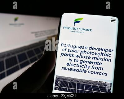 Stoccarda, Germania, 12-04-2022: Persona che possiede uno smartphone con sito web e logo della società energetica portoghese Frequent Summer S.A. sullo schermo. Concentrati su Foto Stock