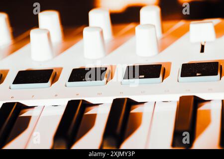 Tastiera bianca con tasti neri. La tastiera viene posizionata su un tavolo. Controller Midi tastiera Foto Stock