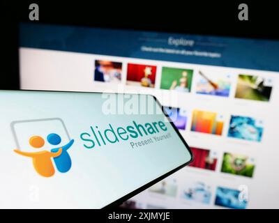 Stoccarda, Germania, 12-31-2022: Smartphone con logo della società di hosting di contenuti SlideShare sullo schermo di fronte al sito Web aziendale. Concentrati sul centro di Foto Stock