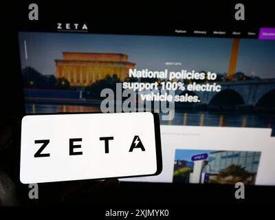 Stoccarda, Germania, 01-06-2023: Persona in possesso di uno smartphone con il logo della Zero Emission Transportation Association (ZETA) sullo schermo di fronte al sito web. Foto Stock