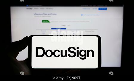 Stoccarda, Germania, 01-13-2023: Persona che detiene un cellulare con il logo della società americana di firma elettronica DocuSign Inc. Sullo schermo di fronte Foto Stock