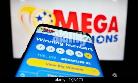 Stoccarda, Germania, 01-13-2023: Smartphone con sito web del gioco della lotteria USA Mega Millions sullo schermo davanti al logo. Concentrati sulla parte superiore sinistra del telefono Foto Stock