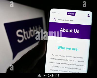 Stoccarda, Germania, 01-25-2023: Persona che detiene il cellulare con il sito web della società di biglietteria statunitense StubHub sullo schermo davanti al logo aziendale. Concentrati su Foto Stock