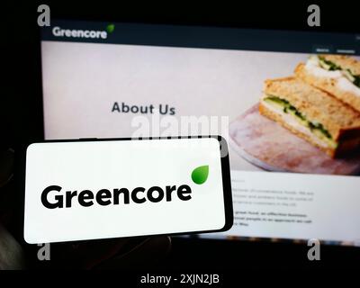 Stoccarda, Germania, 03-09-2023: Persona che detiene un cellulare con il logo della società alimentare irlandese Greencore Group plc sullo schermo di fronte alla pagina web aziendale. Foto Stock