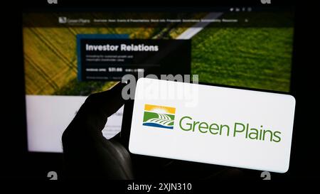 Stoccarda, Germania, 03-12-2023: Persona che detiene un cellulare con il logo della società statunitense di etanolo Green Plains Inc. Sullo schermo di fronte alla pagina web aziendale. Foto Stock