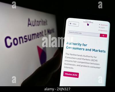 Stoccarda, Germania, 03-12-2023: Persona che possiede uno smartphone con pagina Web del regolatore olandese Autoriteit Consument en Markt (ACM) sullo schermo. Concentrati su Foto Stock