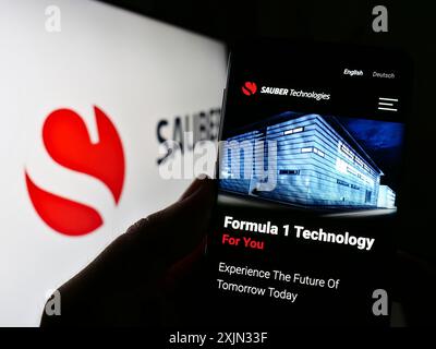 Stoccarda, Germania, 03-12-2023: Persona che detiene il cellulare con pagina web dell'azienda automobilistica svizzera Sauber Motorsport AG sullo schermo con logo. Concentrati su Foto Stock