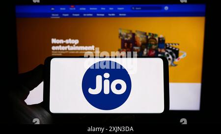 Stoccarda, Germania, 03-18-2023: Persona che detiene il cellulare con il logo della società indiana di telecomunicazioni Reliance Jio sullo schermo davanti alla pagina web. Foto Stock