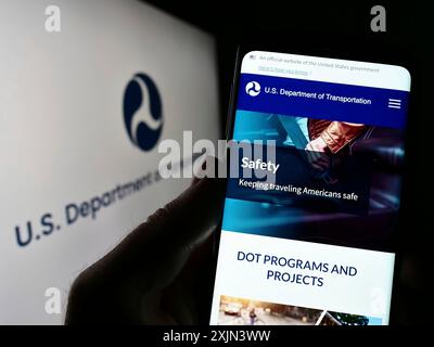 Stoccarda, Germania, 03-22-2023: Persona che tiene il cellulare con pagina web del Dipartimento dei trasporti degli Stati Uniti (USDOT) sullo schermo con il logo. Foto Stock